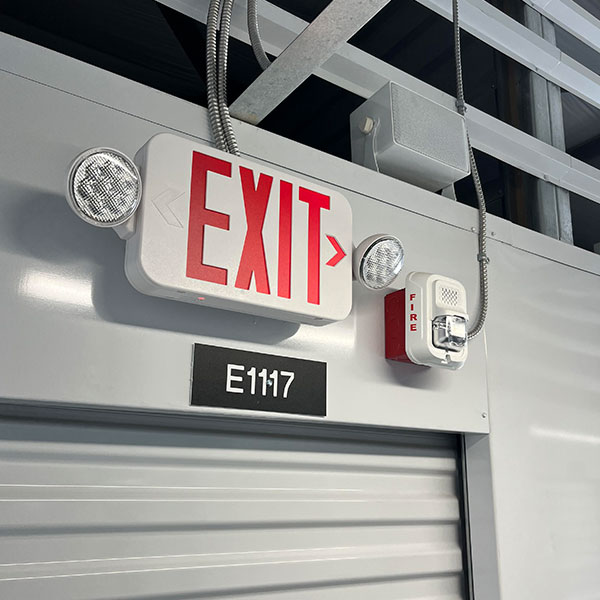 Exit sign with alarm mounted above a door